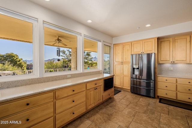 kitchen with a mountain view, plenty of natural light, light brown cabinets, and stainless steel fridge