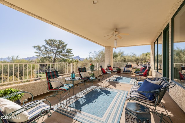 view of patio featuring ceiling fan, a mountain view, and a balcony