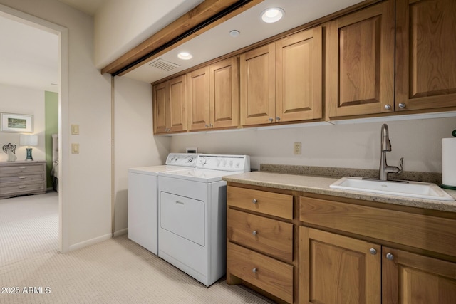 clothes washing area featuring light carpet, cabinets, washing machine and clothes dryer, and sink