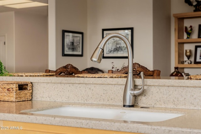 details featuring light stone counters and sink