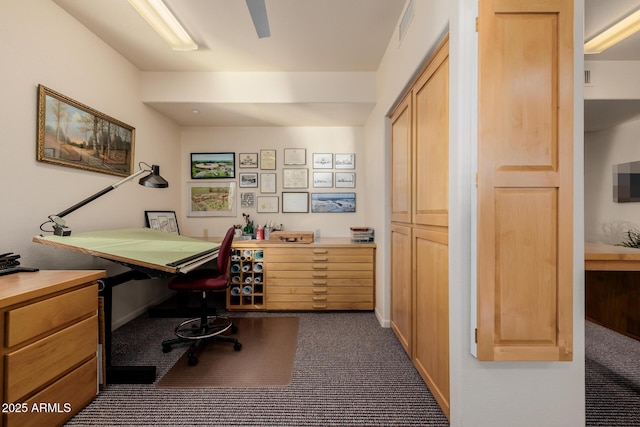 home office with built in desk and dark colored carpet