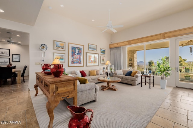 living room featuring ceiling fan and a high ceiling