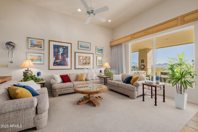 living room with ceiling fan and a towering ceiling