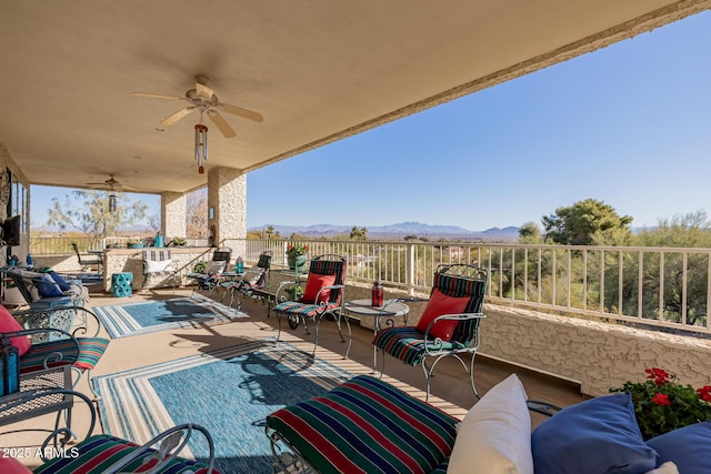 view of patio / terrace with ceiling fan, an outdoor living space, and a mountain view