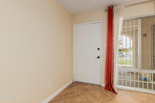 foyer with baseboards and light tile patterned floors