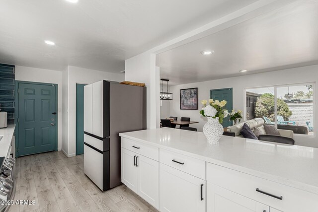 1814 W Thomas Rd, Phoenix, AZ 85015 - kitchen with freestanding refrigerator, light wood-style flooring, light countertops, white cabinets, and recessed lighting