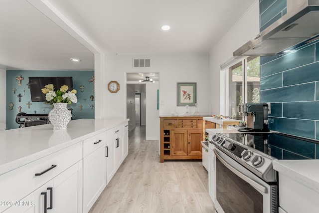 1814 W Thomas Rd, Phoenix, AZ 85015 - kitchen with electric stove, wall chimney exhaust hood, light wood-type flooring, white cabinetry, and recessed lighting