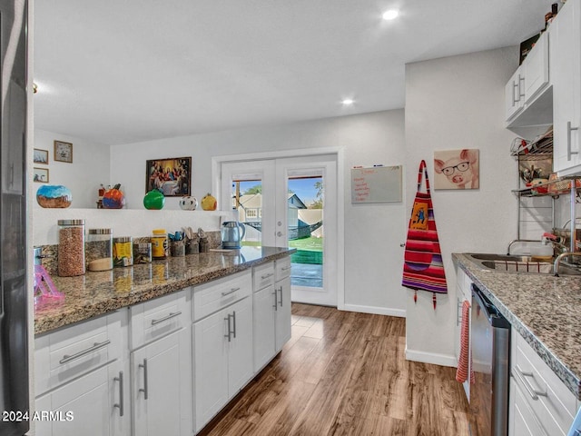 kitchen featuring dishwasher, french doors, white cabinets, dark stone countertops, and light wood-type flooring