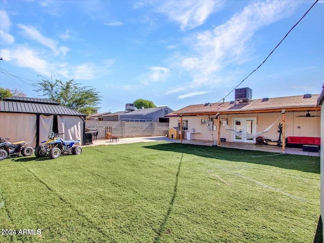 view of yard featuring central AC, french doors, and a patio