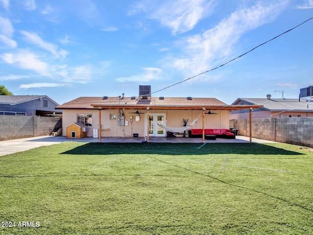 rear view of property featuring outdoor lounge area, ceiling fan, a yard, french doors, and a patio