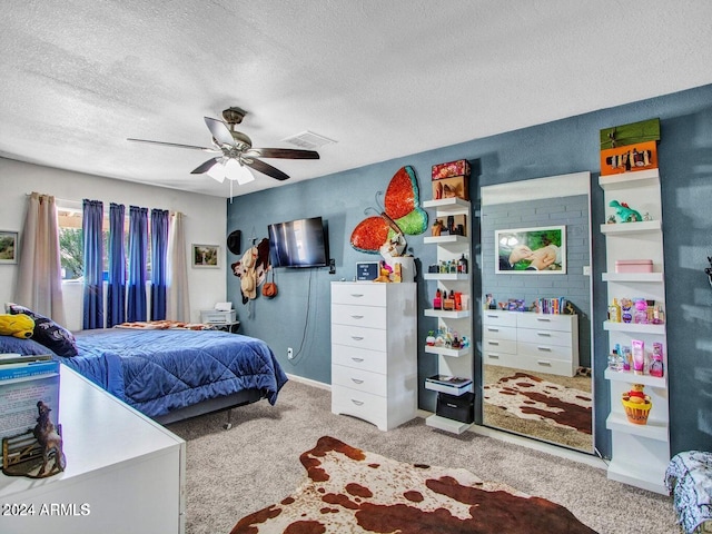 carpeted bedroom with ceiling fan and a textured ceiling