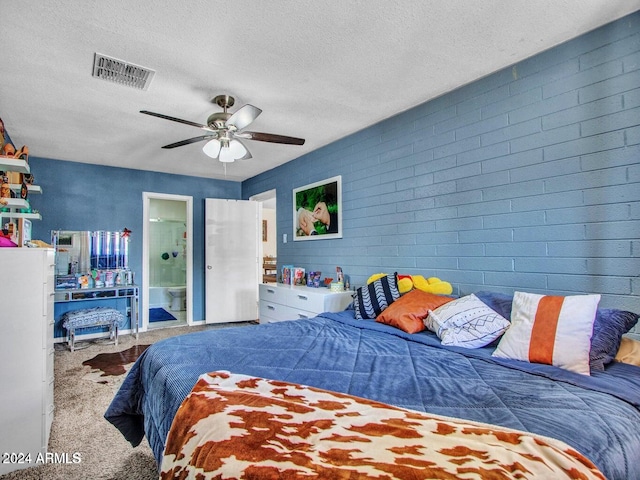 bedroom with carpet flooring, ceiling fan, ensuite bathroom, and a textured ceiling