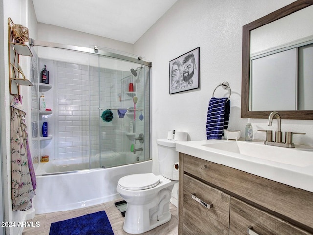 full bathroom featuring vanity, enclosed tub / shower combo, and toilet