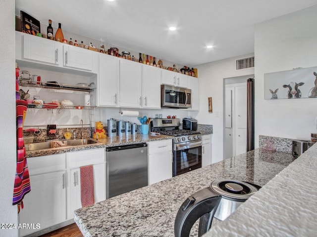 kitchen featuring light stone countertops, white cabinetry, and stainless steel appliances