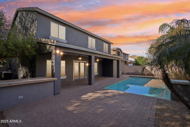 view of swimming pool featuring a fenced in pool, a fenced backyard, a patio, and ceiling fan