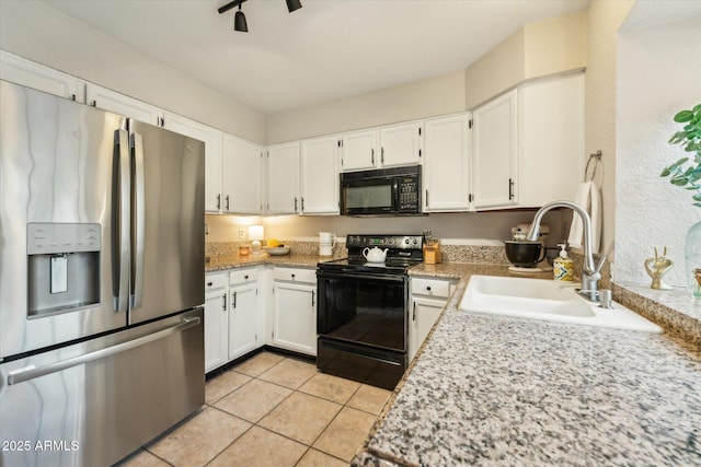 kitchen with light tile patterned floors, a sink, black appliances, light countertops, and white cabinetry