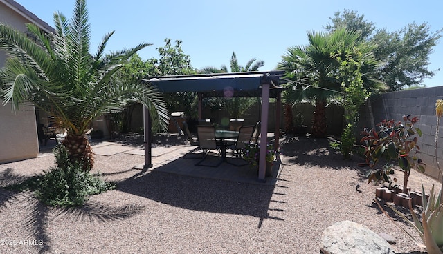 view of yard with a fenced backyard, outdoor dining space, and a patio