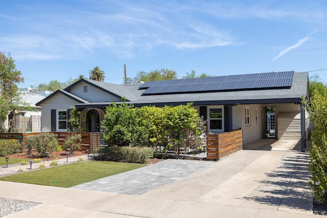 546 W Cambridge Ave, Phoenix, AZ 85003 - view of front of home with a shingled roof, concrete driveway, solar panels, and a front lawn