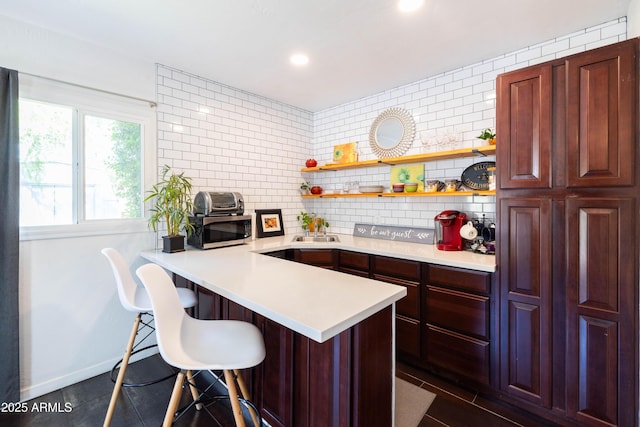 546 W Cambridge Ave, Phoenix, AZ 85003 - kitchen featuring stainless steel microwave, light countertops, a breakfast bar, open shelves, and recessed lighting