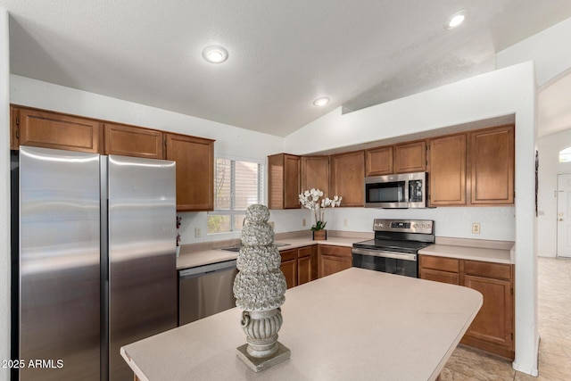 626 W Catclaw St, Gilbert, AZ 85233 - kitchen featuring vaulted ceiling, light countertops, brown cabinetry, and stainless steel appliances
