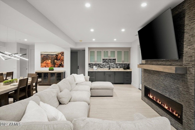 living room with a fireplace, light tile patterned floors, and indoor wet bar