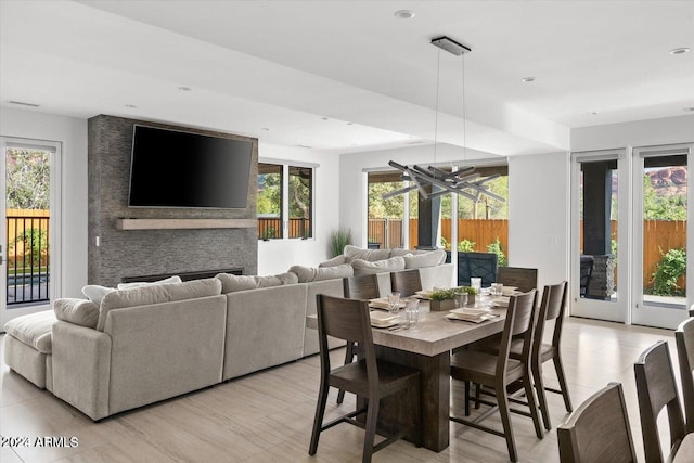 dining room with a fireplace, plenty of natural light, and light hardwood / wood-style flooring