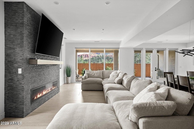 living room featuring light wood-type flooring and a stone fireplace