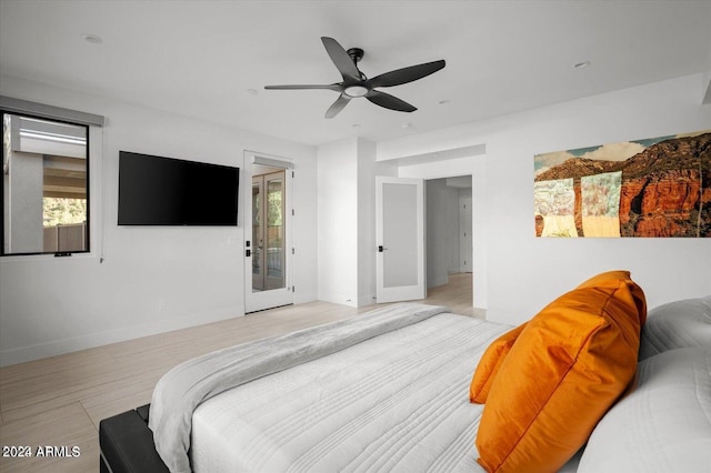 bedroom with multiple windows, ceiling fan, french doors, and light hardwood / wood-style floors