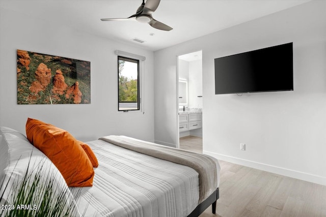 bedroom featuring ceiling fan, ensuite bath, and light hardwood / wood-style floors