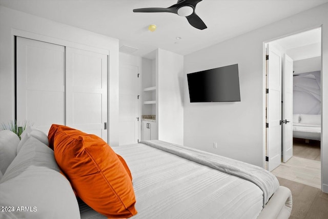 bedroom with a closet, light hardwood / wood-style flooring, and ceiling fan