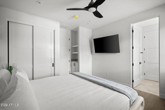 bedroom featuring ceiling fan, a closet, and hardwood / wood-style floors