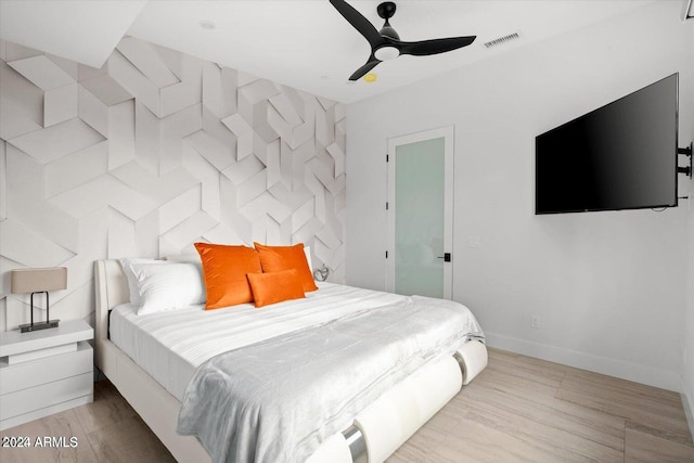 bedroom with light hardwood / wood-style flooring and ceiling fan