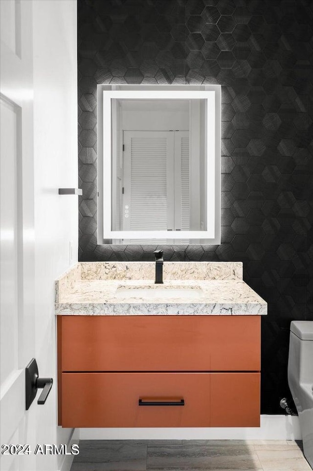 bathroom with vanity, tile walls, and toilet