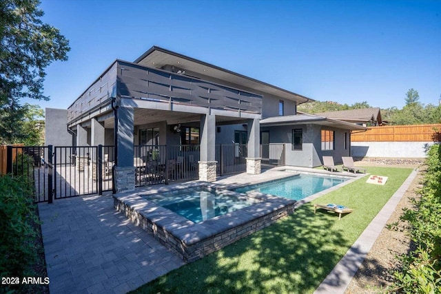 back of house featuring a pool with hot tub and a patio area