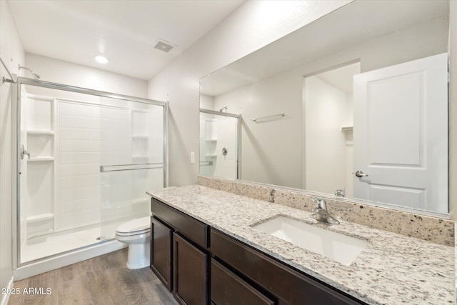 431 W Guinea Ct, Casa Grande, AZ 85122 - full bathroom with a stall shower, visible vents, toilet, wood finished floors, and vanity