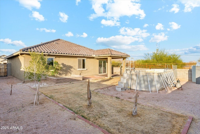 431 W Guinea Ct, Casa Grande, AZ 85122 - back of property featuring a fenced backyard, a tile roof, a fenced in pool, and stucco siding