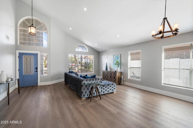 living area with a notable chandelier, plenty of natural light, baseboards, and wood finished floors