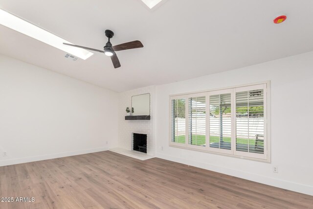 4310 E Sacaton St, Phoenix, AZ 85044 - unfurnished living room featuring a ceiling fan, visible vents, a brick fireplace, light wood-type flooring, and baseboards