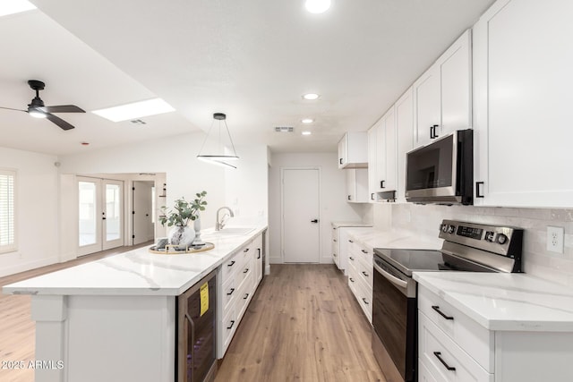 4310 E Sacaton St, Phoenix, AZ 85044 - kitchen with visible vents, beverage cooler, white cabinets, light wood-style flooring, and stainless steel appliances