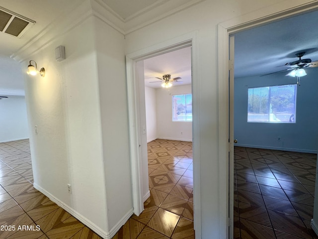hallway featuring crown molding and baseboards