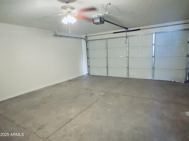 garage featuring a garage door opener, baseboards, and ceiling fan