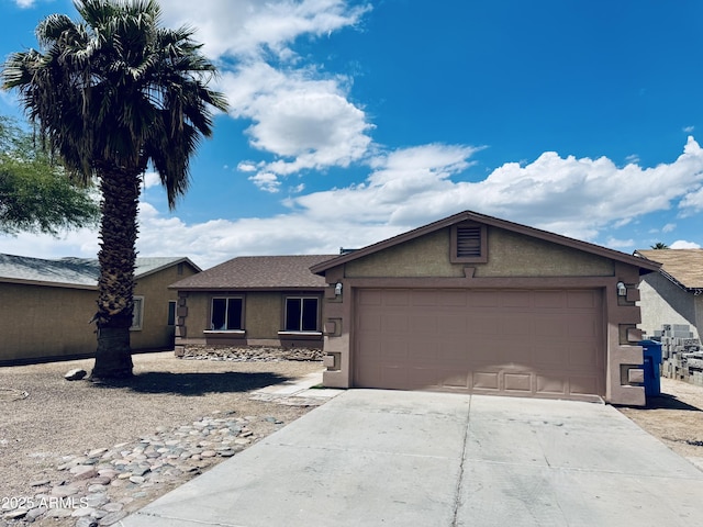 single story home featuring stucco siding, an attached garage, and concrete driveway