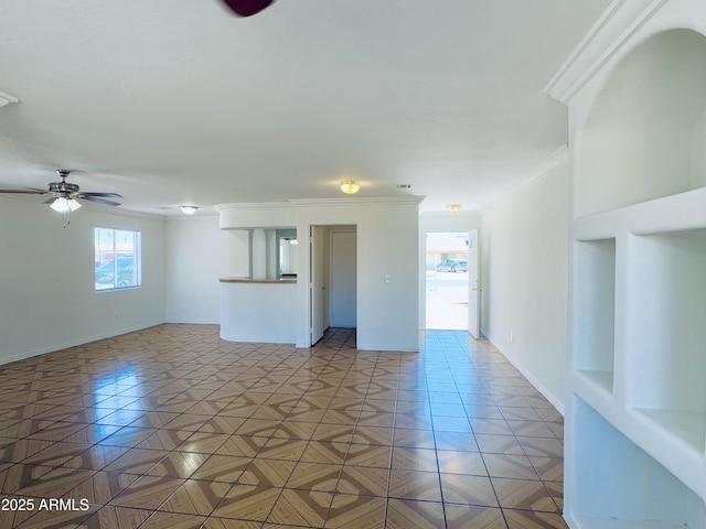 unfurnished living room featuring ornamental molding, ceiling fan, and baseboards