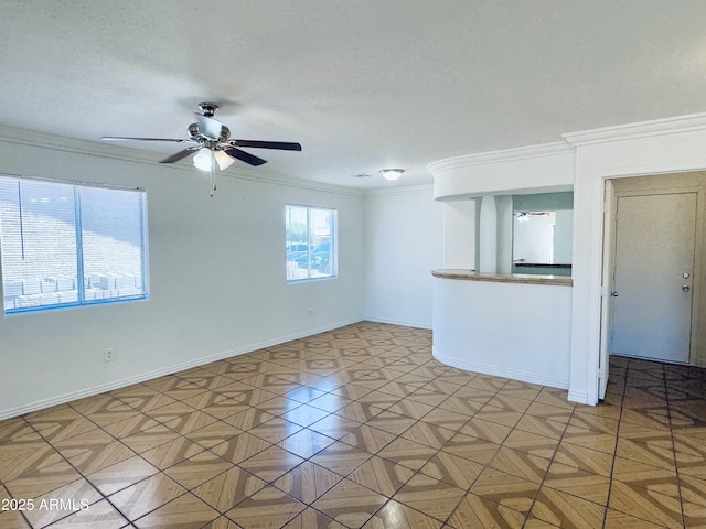 spare room with a ceiling fan, crown molding, baseboards, and a textured ceiling