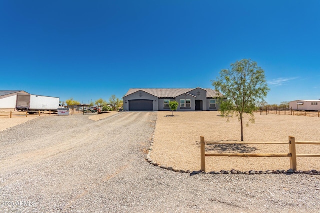 32431 N 226th Ave, Wittmann, AZ 85361 - view of front of house featuring an attached garage, a tiled roof, gravel driveway, and stucco siding