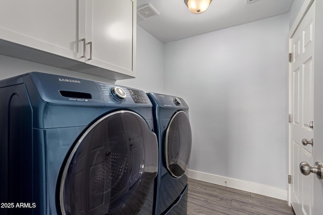 32431 N 226th Ave, Wittmann, AZ 85361 - laundry area featuring washing machine and clothes dryer, baseboards, cabinet space, and wood finished floors