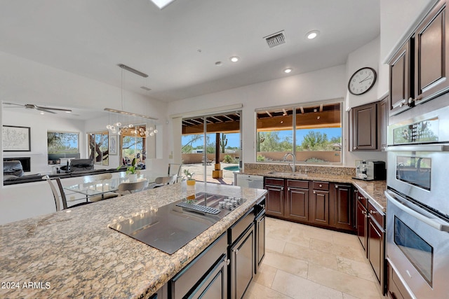 kitchen featuring ceiling fan, double oven, sink, and a wealth of natural light