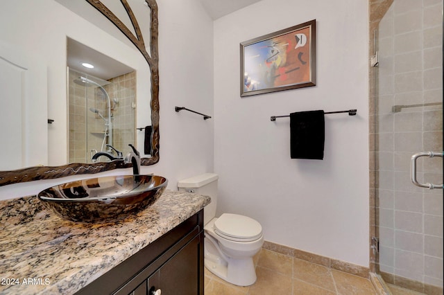 bathroom with tile patterned flooring, vanity, toilet, and an enclosed shower