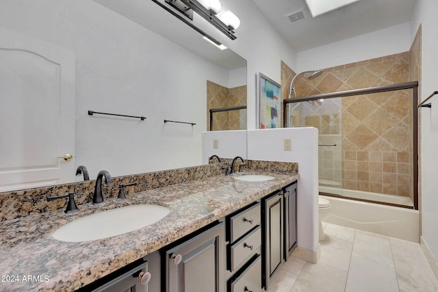 full bathroom featuring shower / bath combination with glass door, vanity, tile patterned flooring, and toilet