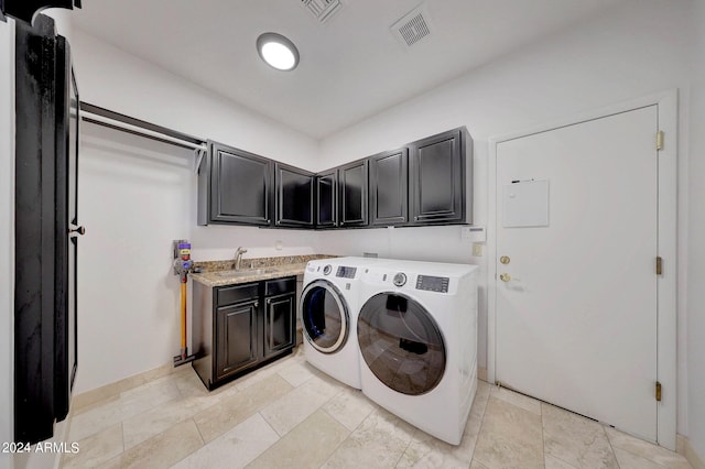 clothes washing area with cabinets, sink, and washing machine and clothes dryer